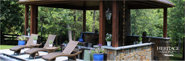 A gazebo with lawn chairs and a kitchen in the backyard