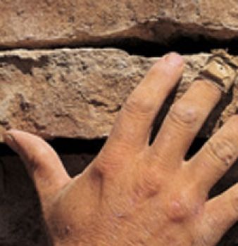 A close up of a person 's hand reaching for a rock