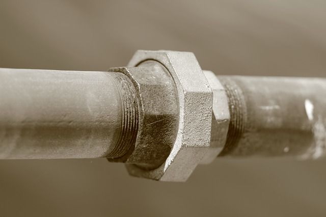 A close up of a metal pipe with a nut on it.