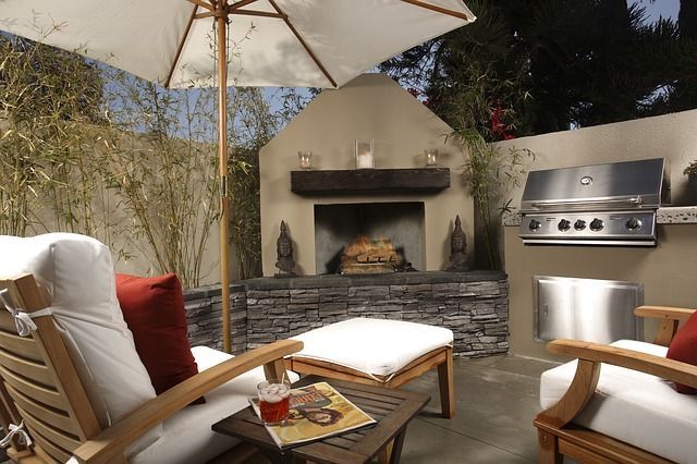 A patio with chairs and umbrellas and a fireplace