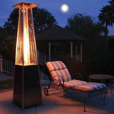 A patio with a chair and a heater at night