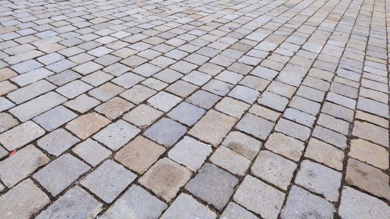 A close up of a brick walkway with a diagonal pattern