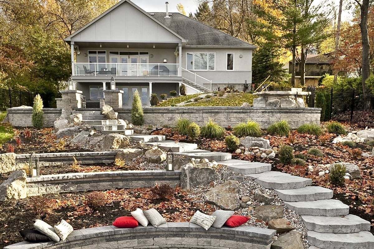 A house with stairs leading up to it and a fire pit in front of it