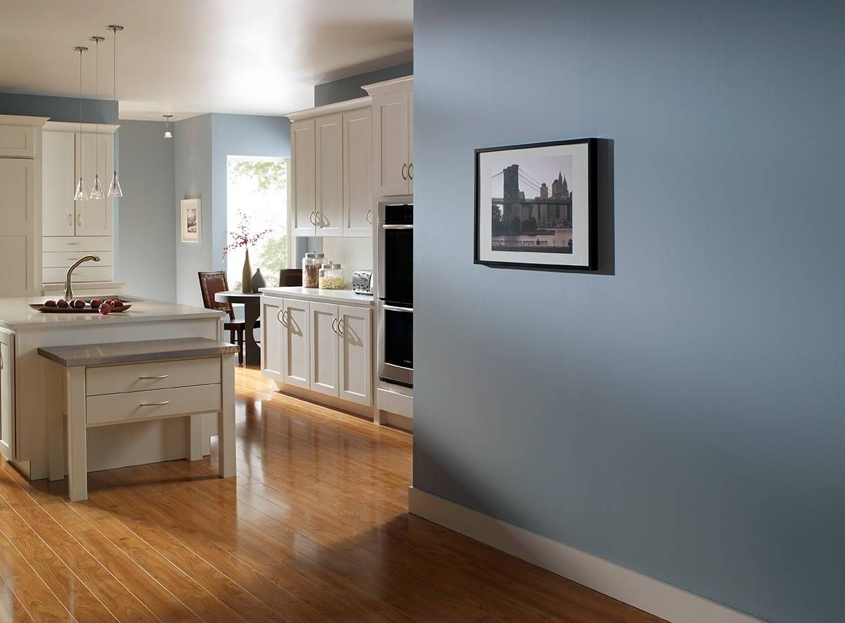 A kitchen with white cabinets and a picture on the wall