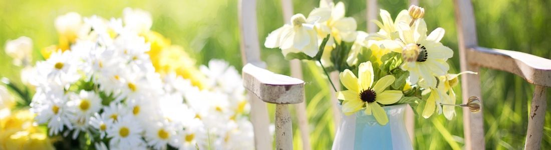 A bunch of flowers are sitting on a wooden fence.