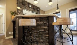 A kitchen with a bar and two bar stools.