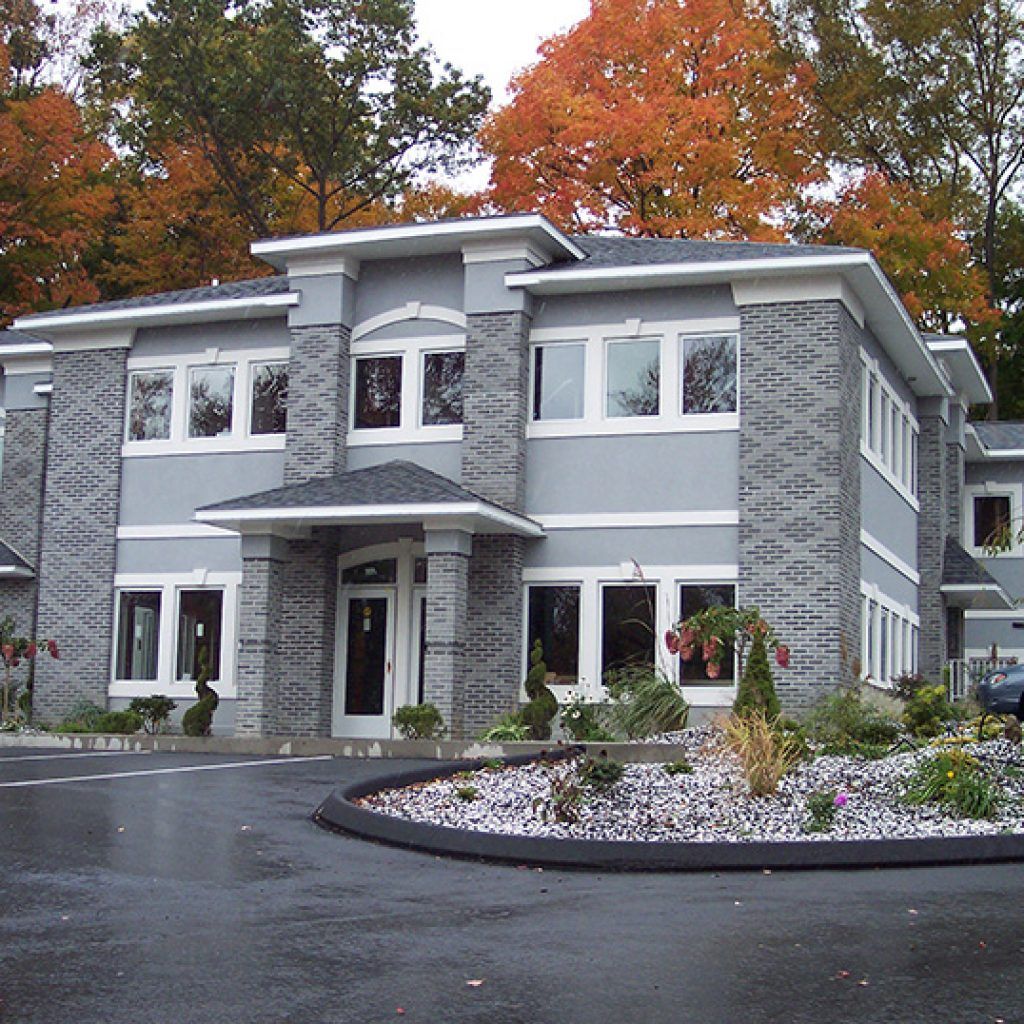 A house with a lot of windows and trees in the background