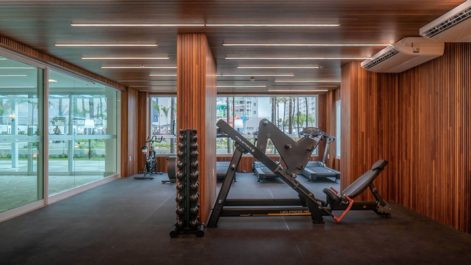 Uma academia com paredes de madeira e uma esteira.