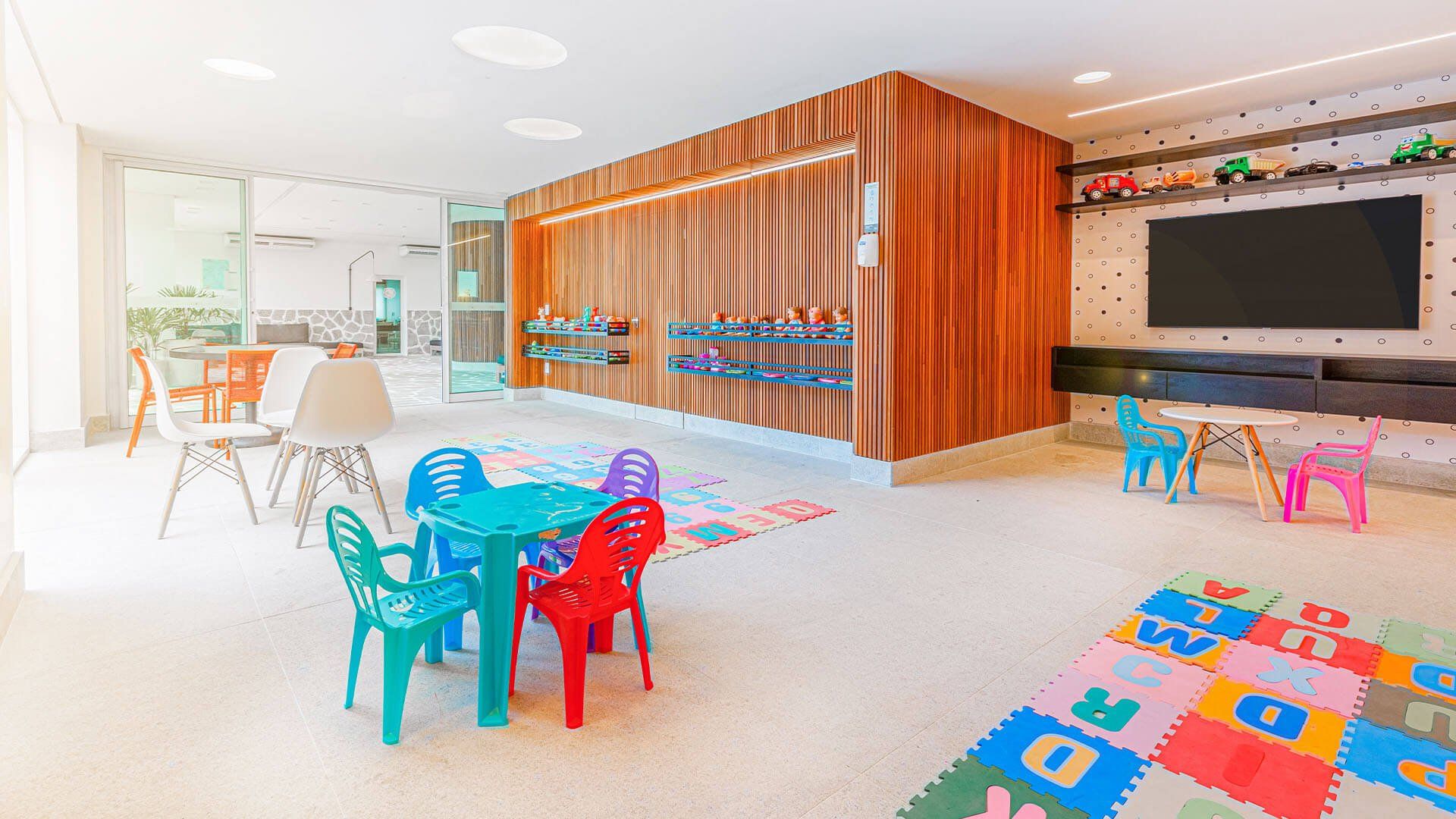 Um quarto infantil com mesas, cadeiras e um tapete.