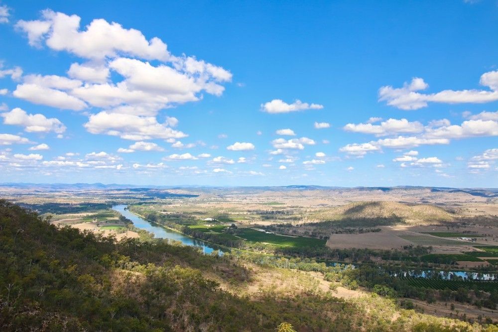 A View Of A Valley With A River And Mountains On A Sunny Day — Kingaroy Crane Trucks & Equipment Hire In Gayndah, QLD
