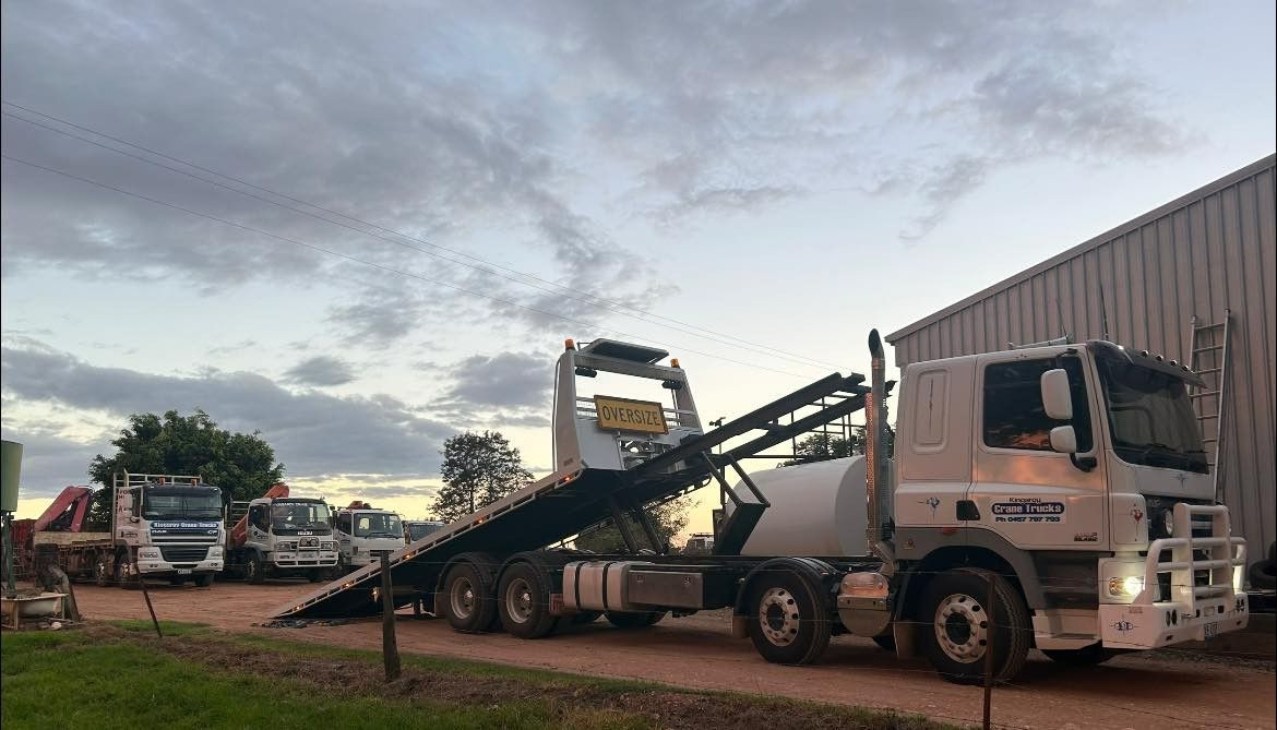 A Tow Truck Is Parked In Front Of A Building — Kingaroy Crane Trucks & Equipment Hire In Kingaroy, QLD