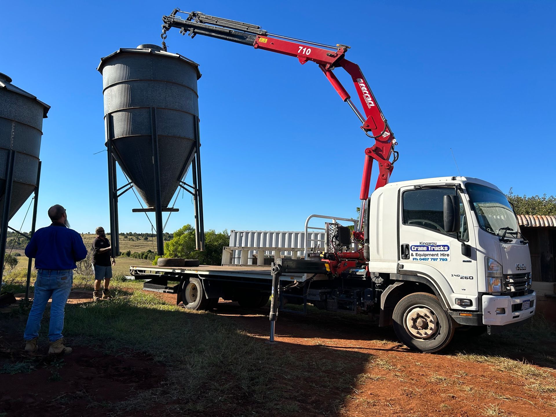 A White Tow Truck Is Carrying A Green Tractor — Kingaroy Crane Trucks & Equipment Hire In Kingaroy, QLD