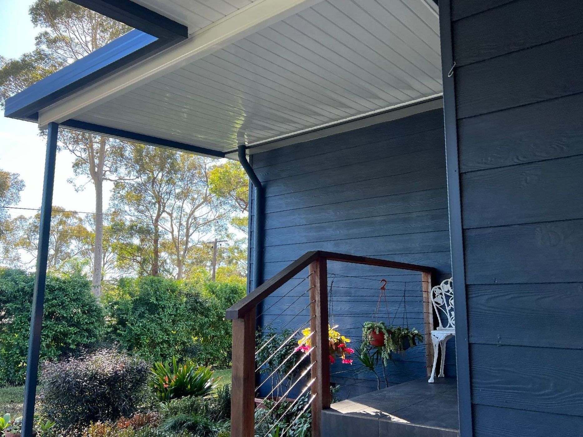 A blue house with a porch and stairs leading up to it.
