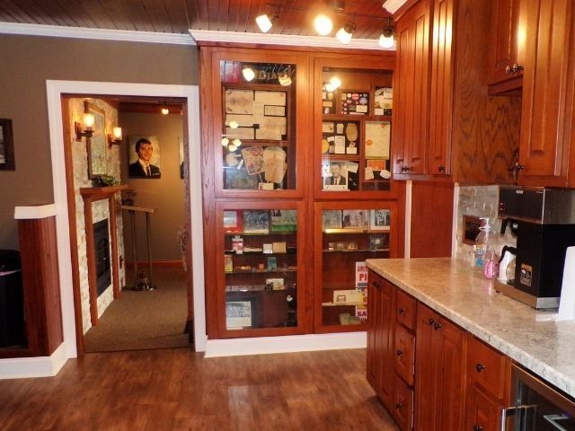 Kitchen with wood cabinets, granite counters, and a glass-front display cabinet in a warm-toned home interior