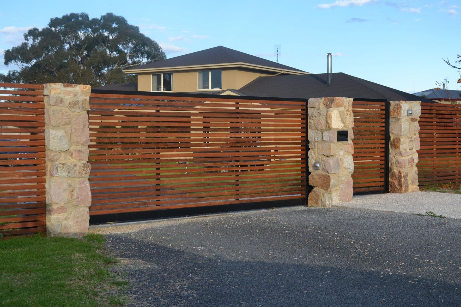 A Wooden Fence Surrounds A Driveway In Front Of A House – East Gippsland, VIC - East Gippsland Garage Doors & Maintenance