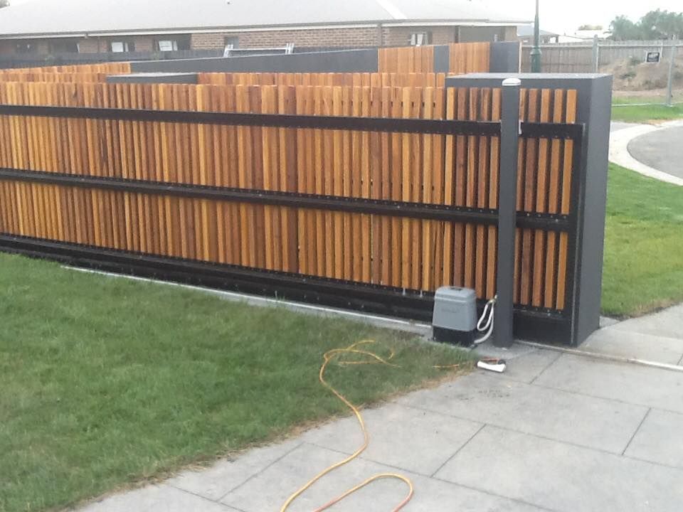 A Wooden Fence With A Sliding Gate In Front Of It – East Gippsland, VIC - East Gippsland Garage Doors & Maintenance