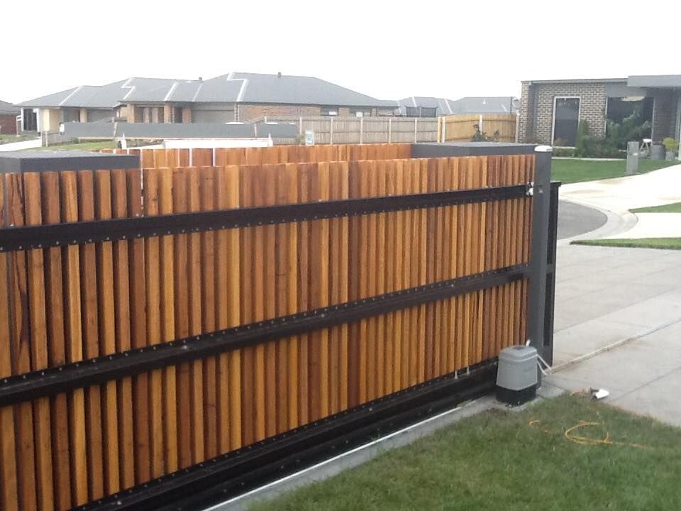 A Wooden Fence With Houses In The Background – East Gippsland, VIC - East Gippsland Garage Doors & Maintenance