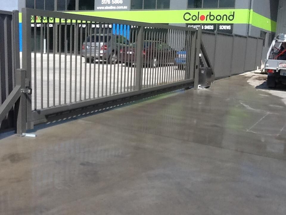 A Sliding Gate In Front Of A Building That Says Colorbond – East Gippsland, VIC - East Gippsland Garage Doors & Maintenance