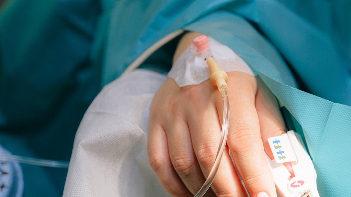 monitoramento de doenças crônicas com tecnologia Mão com cateter intravenoso, enfaixada, em ambiente médico.