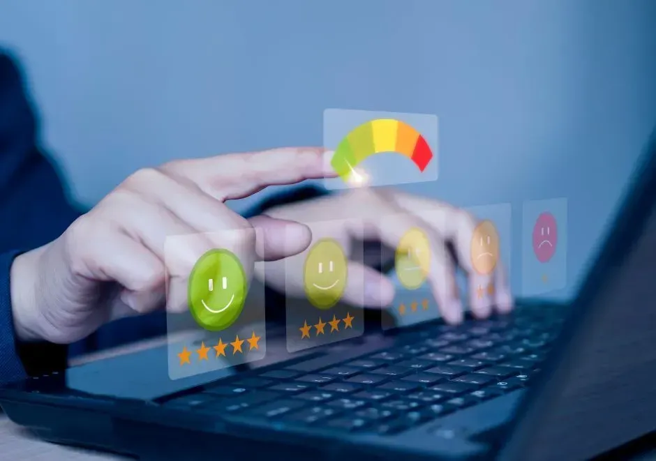 Paciente avaliando atendimento em pesquisa digital via computador Pessoa usando um laptop, interagindo com ícones de feedback digital, incluindo um rosto sorridente e um medidor.