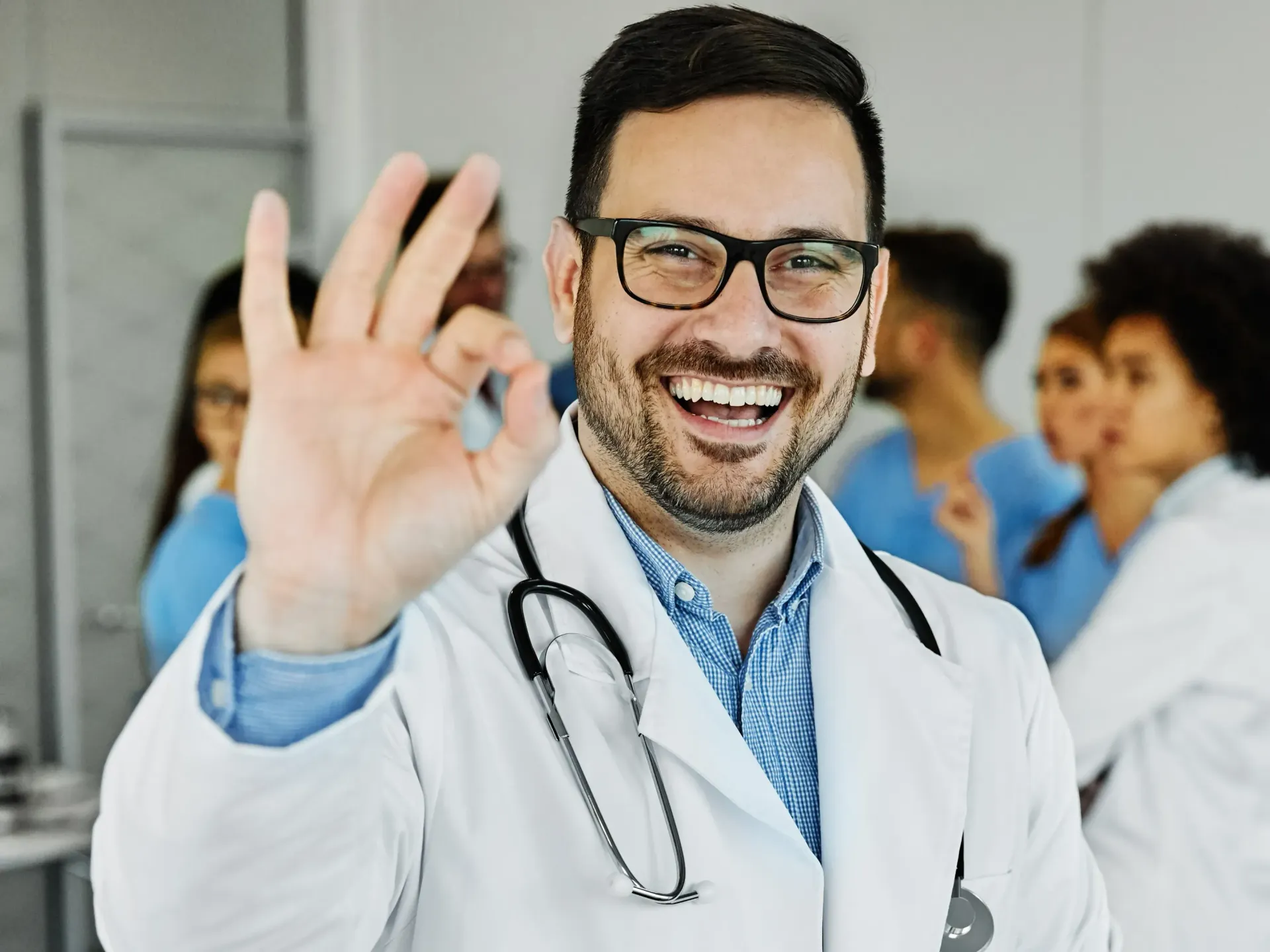 Médico sorrindo e fazendo um gesto de 