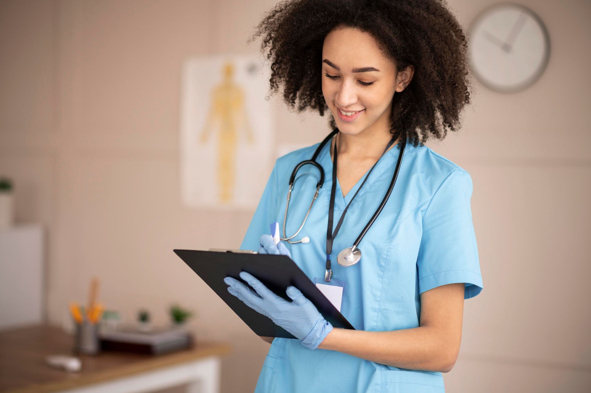 Enfermeira de uniforme azul com estetoscópio, fazendo anotações em uma prancheta em um consultório médico.