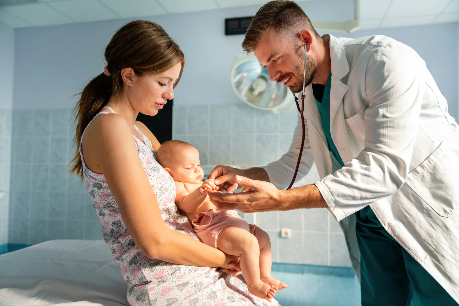 Médico examinando um bebê nos braços da mãe em um ambiente médico.