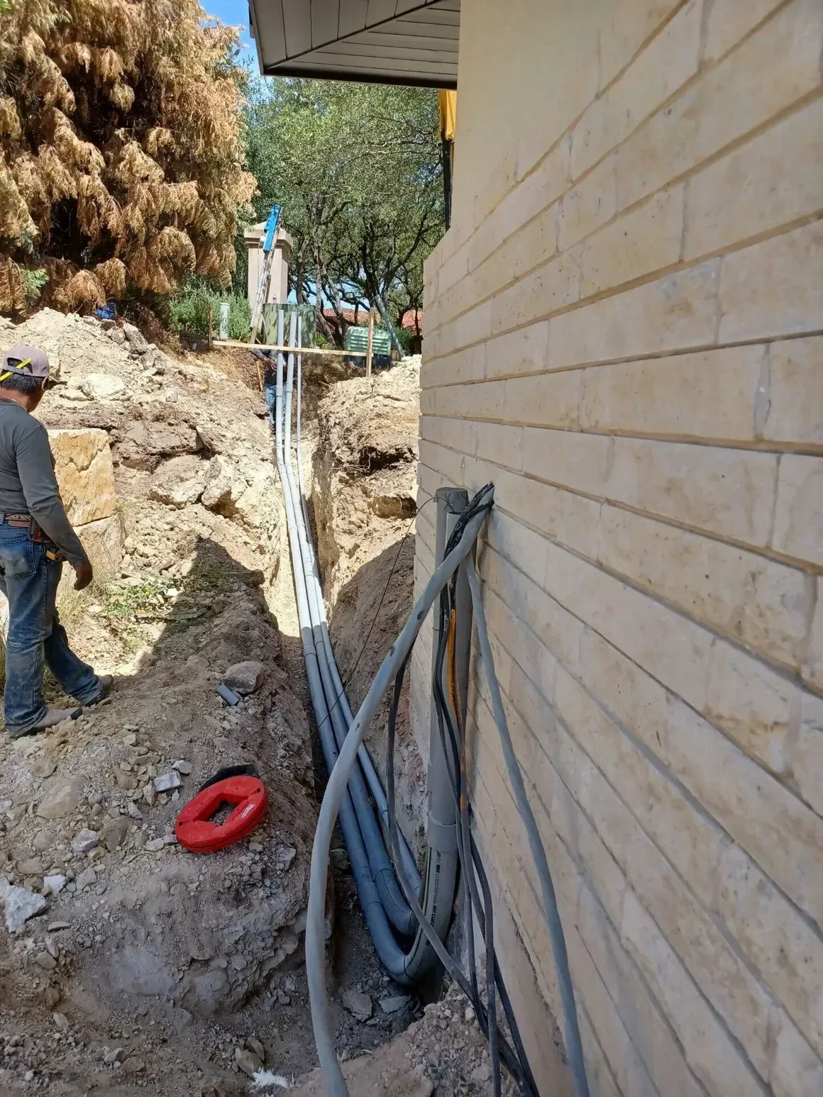 A man is working on the side of a brick building.