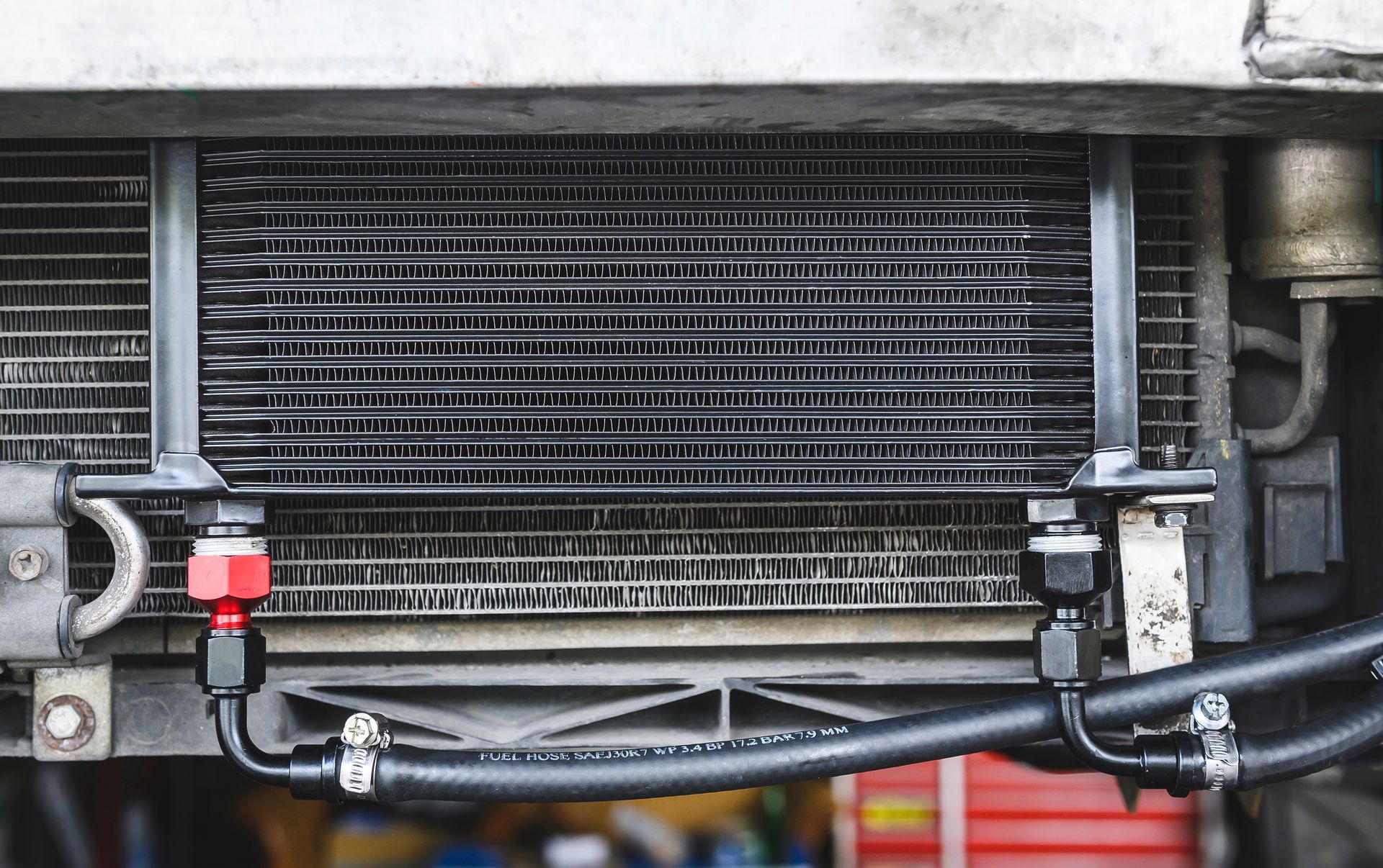 Oil Cooler With Black Hoses and Red Fitting in Front of Car's Radiator — Great Western Auto Wreckers in Orange, NSW