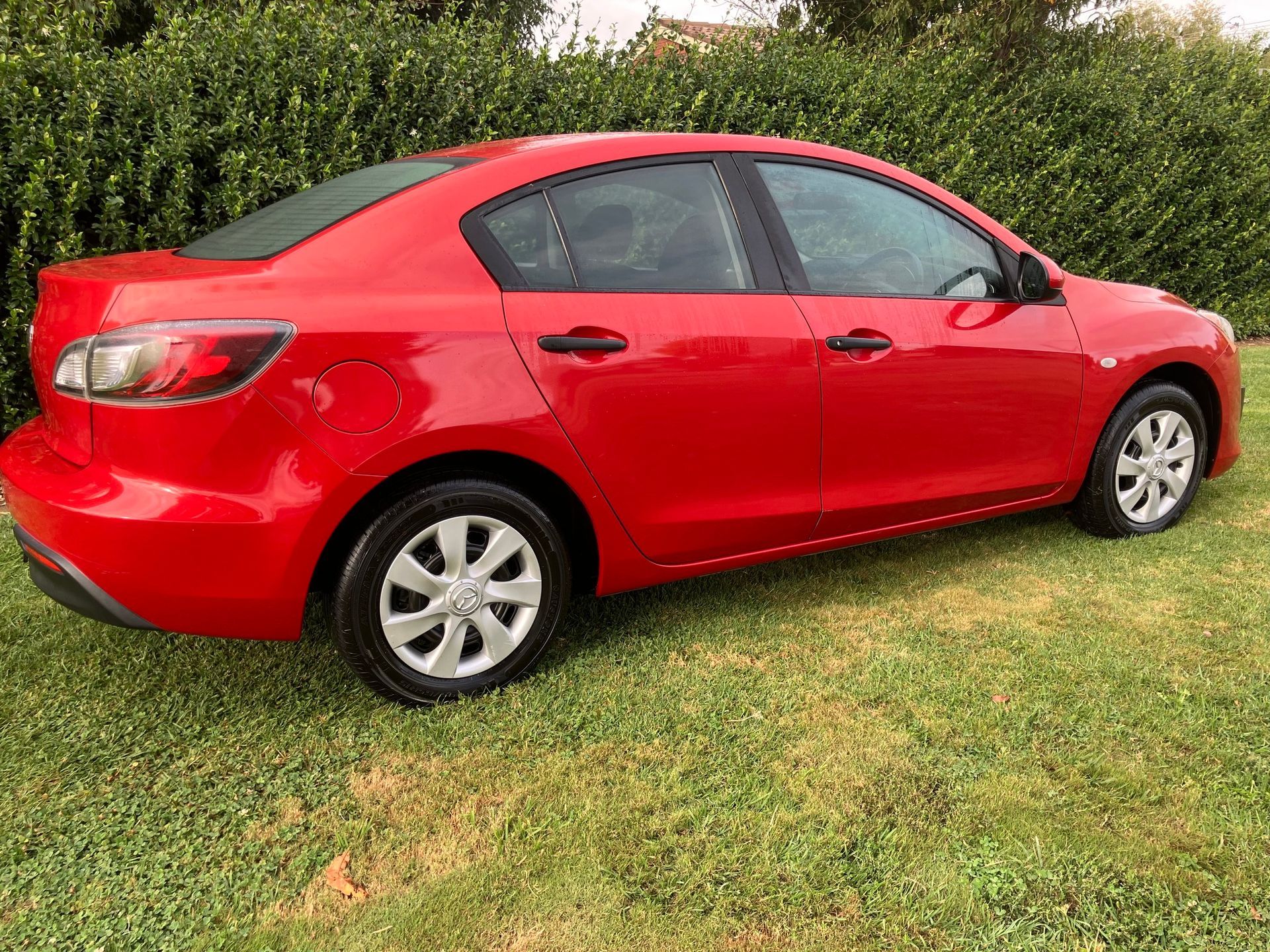 Red Mazda Sedan Parked on Green Grass — Great Western Auto Wreckers in Orange, NSW