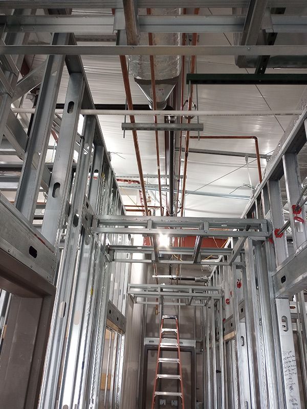 A ladder is hanging from the ceiling of a building under construction.