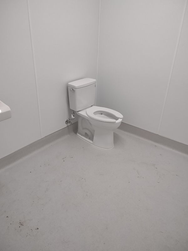 A white toilet is sitting in a bathroom next to a sink.