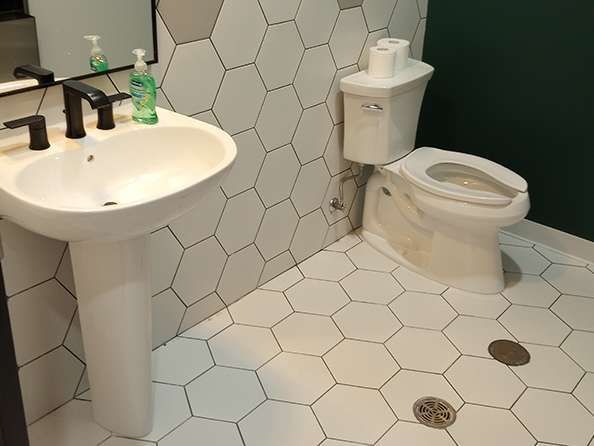 A bathroom with a sink , toilet and mirror.