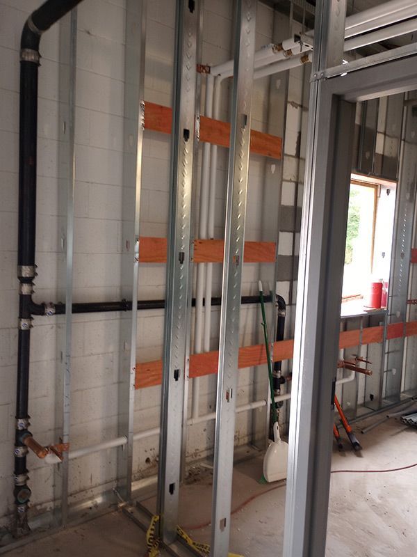 A room with a ladder and pipes in it