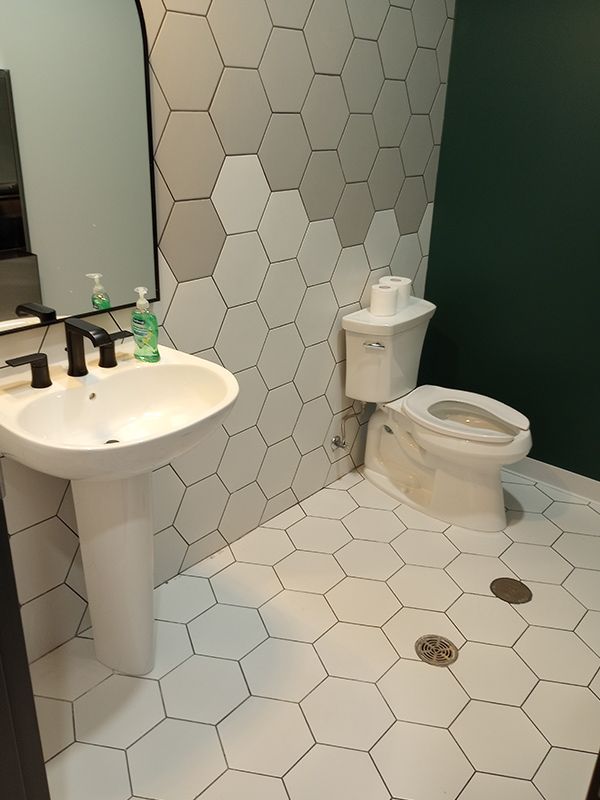 A bathroom with a sink , toilet and mirror.