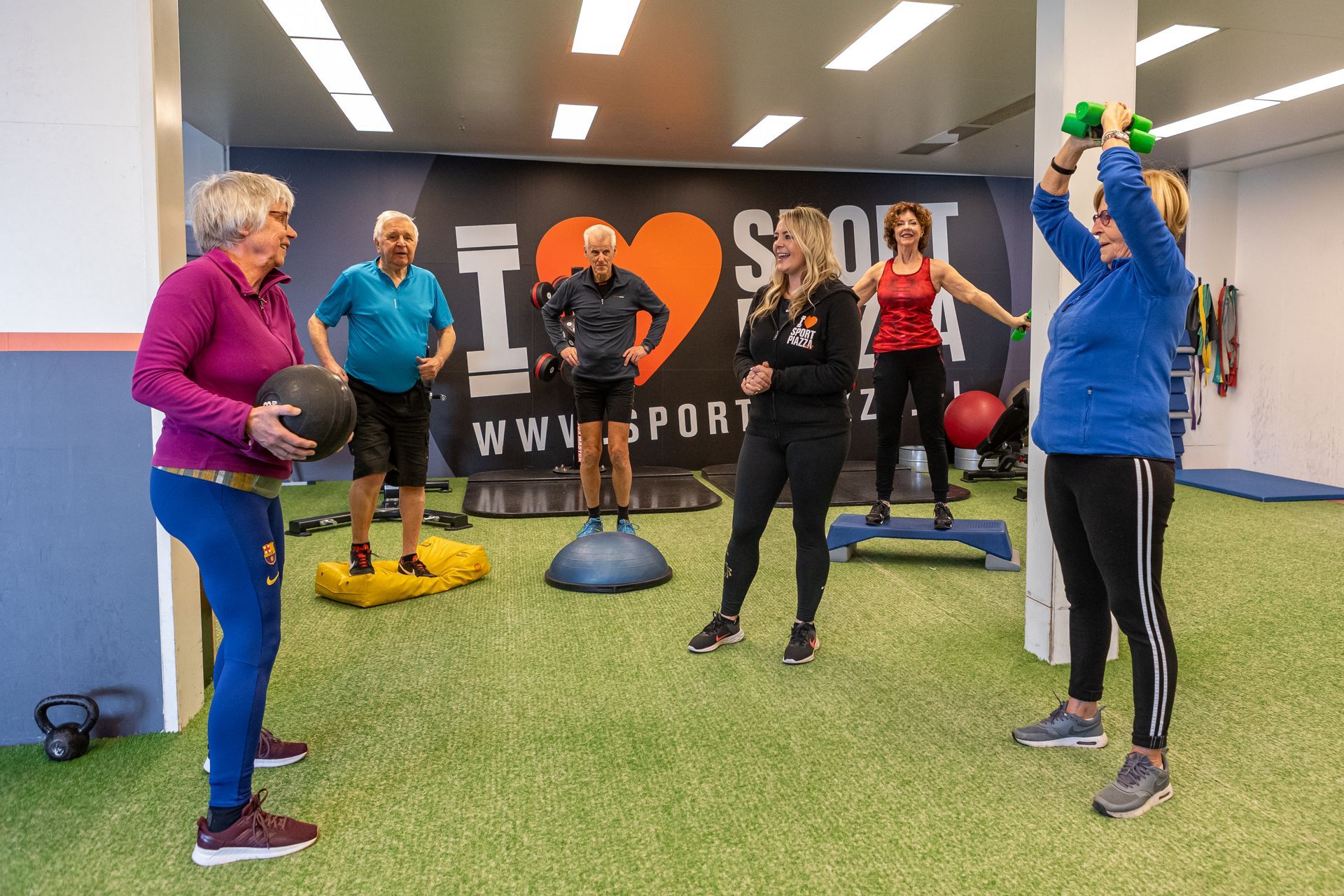 Een groep mensen doet oefeningen in een sportschool.