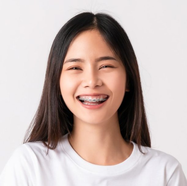 A woman with braces on her teeth is smiling.