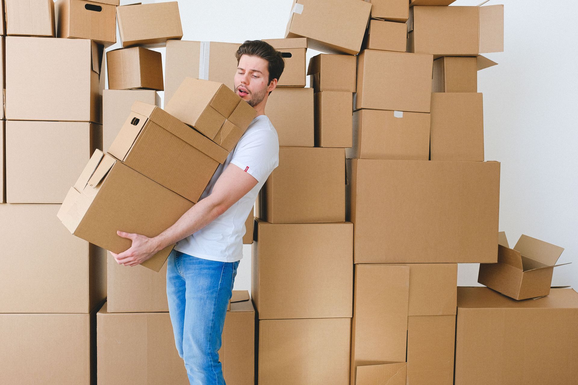 Person Holding Stack of Boxes