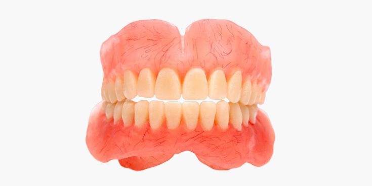 Full set of dentures, upper and lower, with pink gums and off-white teeth, isolated on a white background.