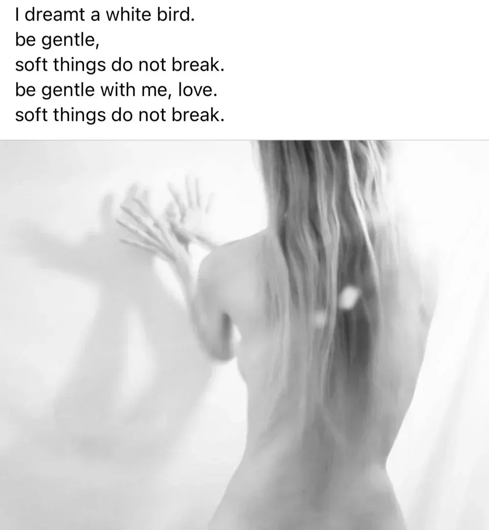 Poem about gentleness. Woman from behind touching a wall. Black and white.