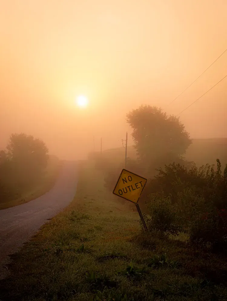 Foggy sunrise over a country road with a 