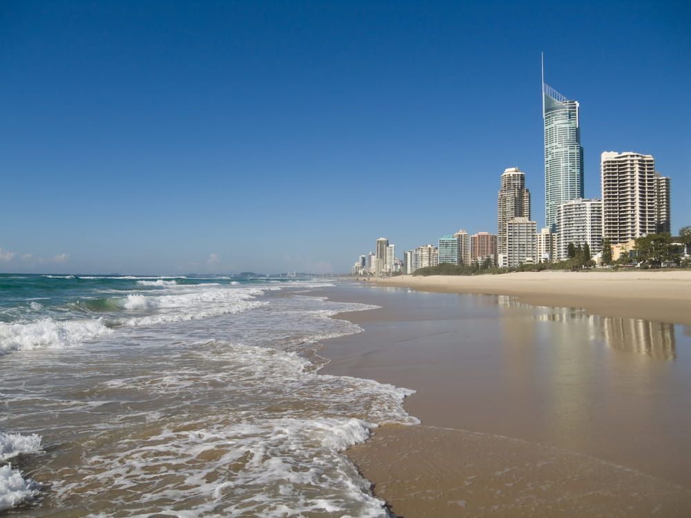 A Beach with A City Skyline in The Background — Bromley's Denture Clinic in Gold Coast, NSW
