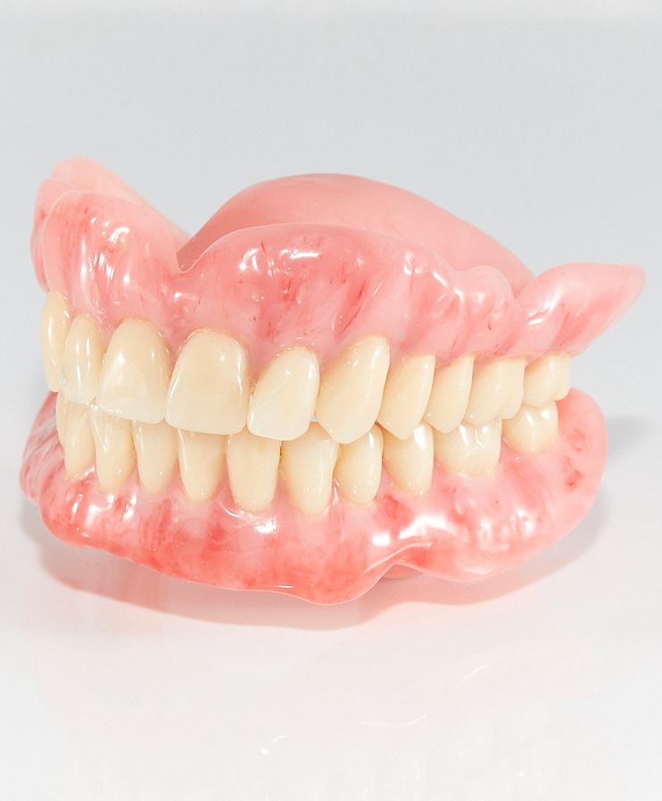 A Close-Up of a Denture on a White Surface — Bromley's Denture Clinic in Tweed Heads South, NSW