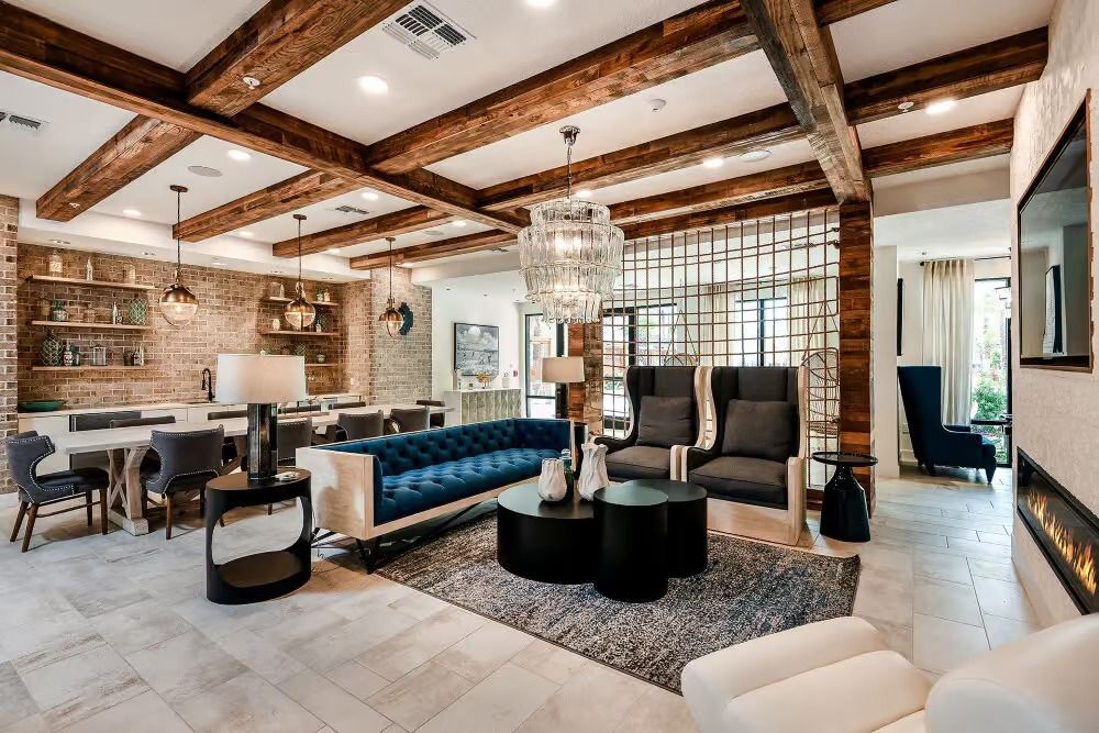 A living room with a couch, two coffee tables, wall art and plants.
