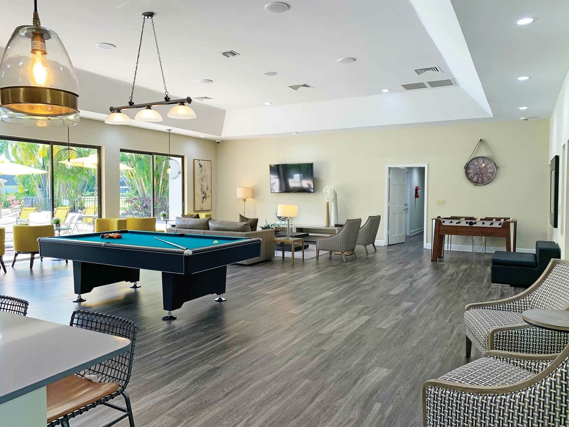 Large community rec room with pool table, seating, and foosball.