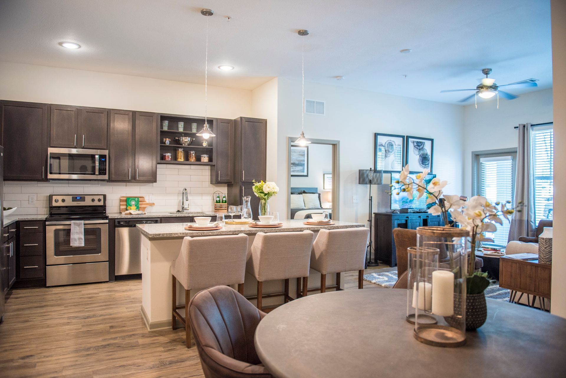 Open-concept kitchen with dark cabinets, stainless steel appliances, and a breakfast bar. Dining are