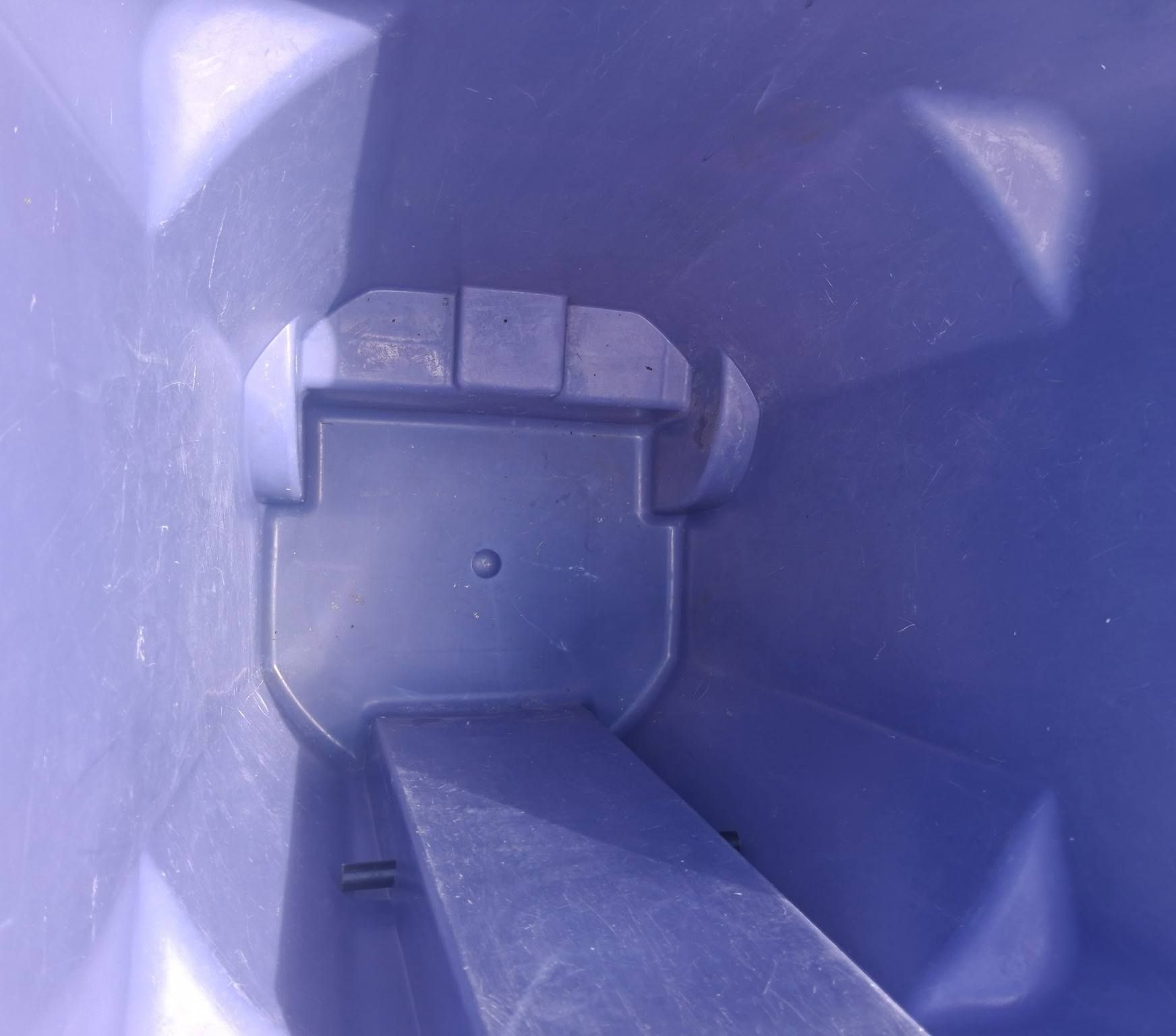Inside a purple plastic bin, looking down into an empty container with a central divider