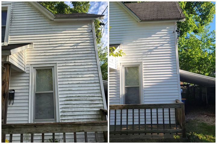 White-sided house exterior with a small porch and trees in the background.