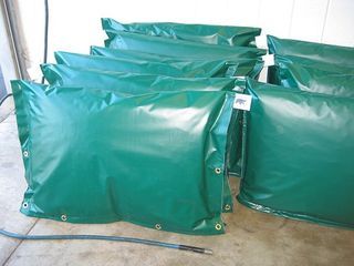 a bunch of green bags are sitting on the floor .