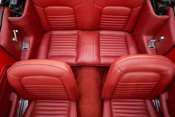 the back seat of a red car with red leather seats
